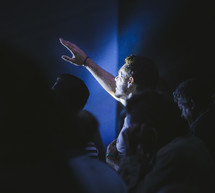 a man in an audience with a raised hand 