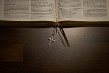 cross necklace between the pages of a Bible 