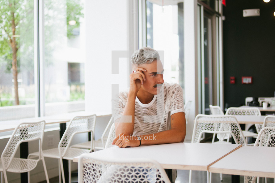 a man sitting alone at a table in a diner 