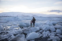 mother and daughter standing on icebergs 