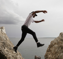 a man leaping between rocks 