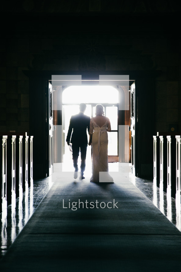 a bride and groom walking out of a church married 