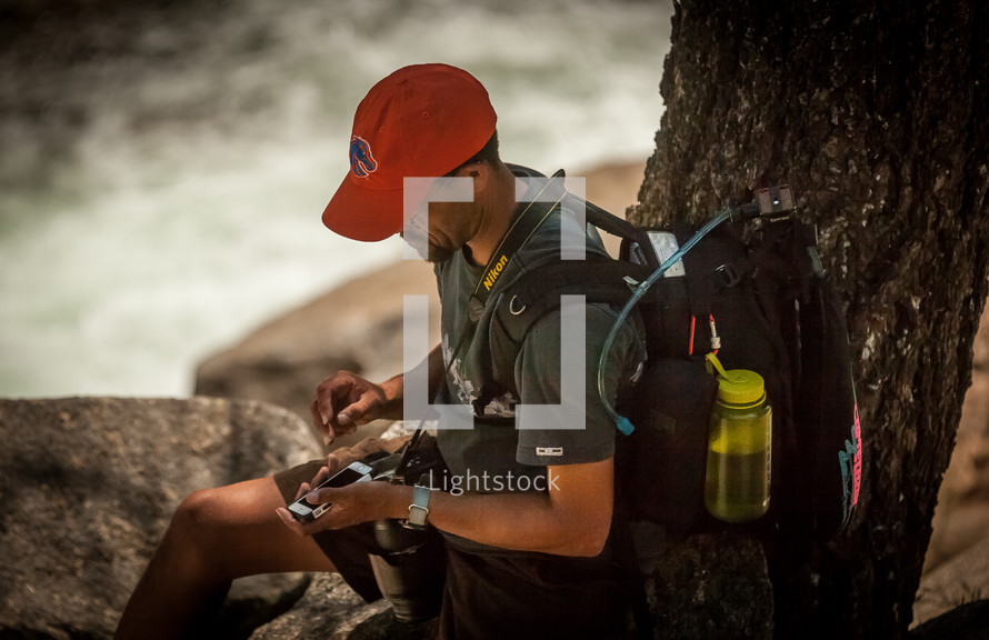 backpacking man checking his cellphone 