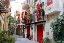 red doors and terraces in a narrow alley 