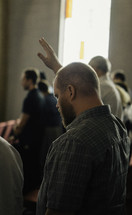 man with a raised hand during a worship service 