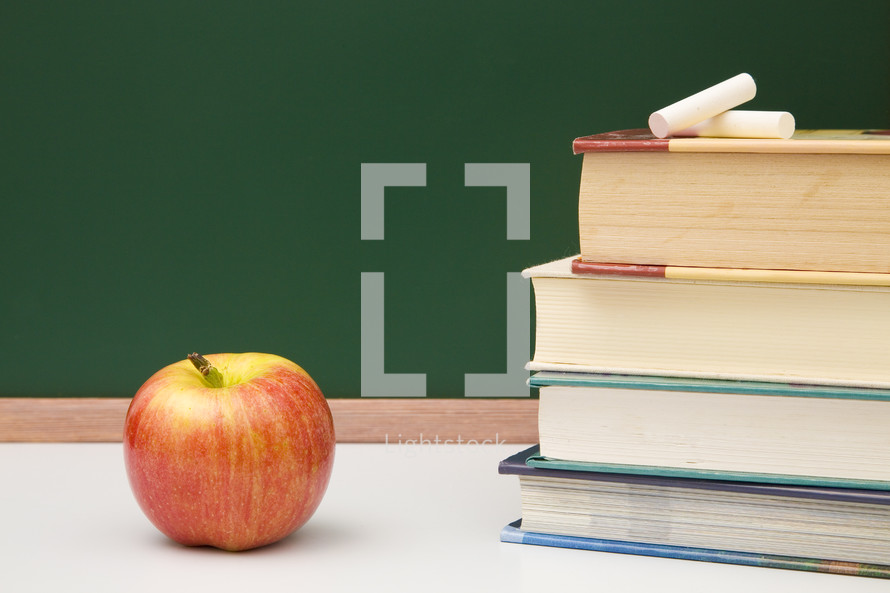 apple, stack of books, and chalkboard 