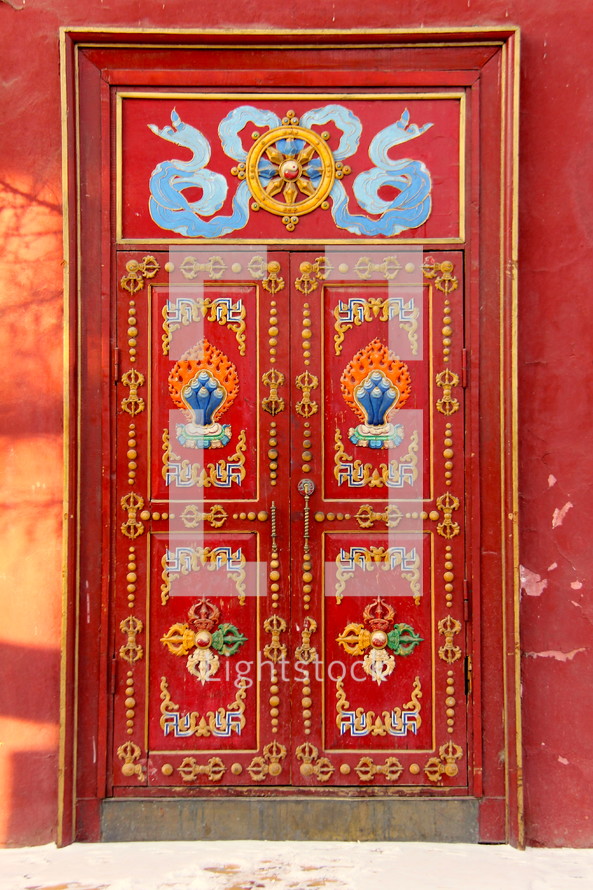 An ornate and detailed red door, entrance to an oriental palace