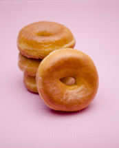 stacked donuts on a pink background 