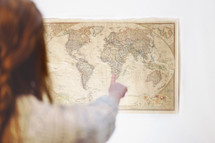 woman pointing to a world map 