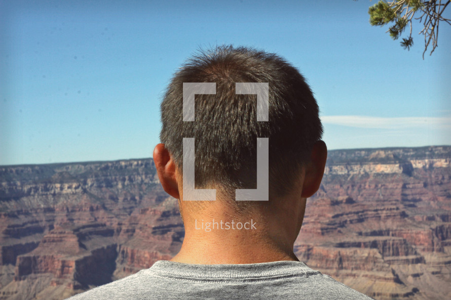man looking out at Grand canyon landscape 