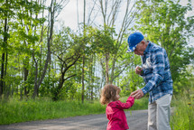 a granddaughter and grandfather walking down a rural road 