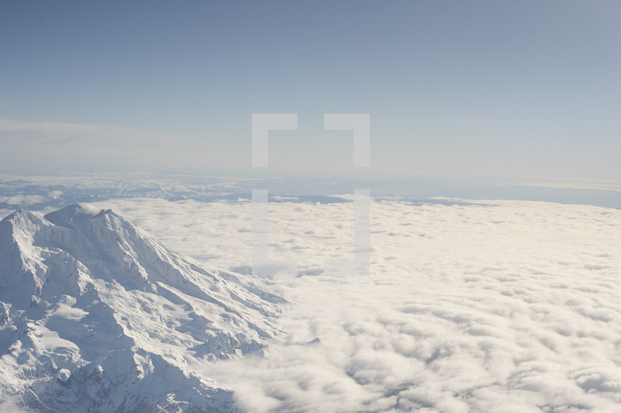 snow capped mountain above the clouds 