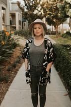 Pretty woman in hat standing outside