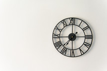 Vintage clock with Roman numeral. wall clock-face dialrustical on white wall in the apartment with copy space