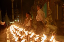 people lighting candles at a festival 