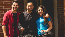 friends standing together holding a guitar case 