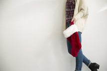 torso of a woman holding a Christmas stocking 