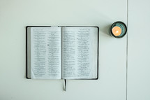 open Bible and votive candle 
