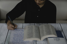 a young man journaling and reading a Bible 