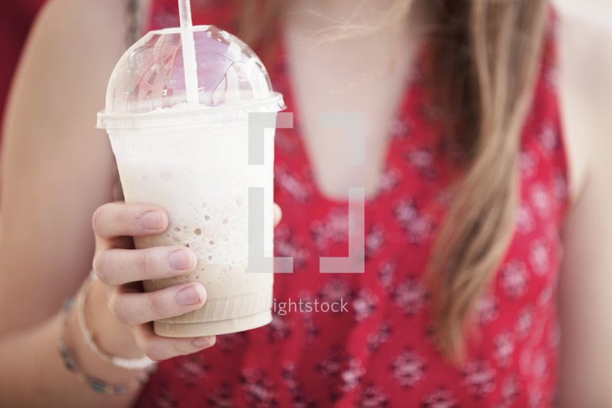 Hand holding a frozen latte.