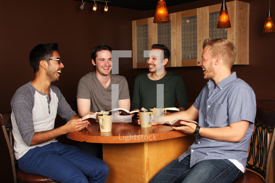 men sitting at a table with Bibles and coffee mugs 