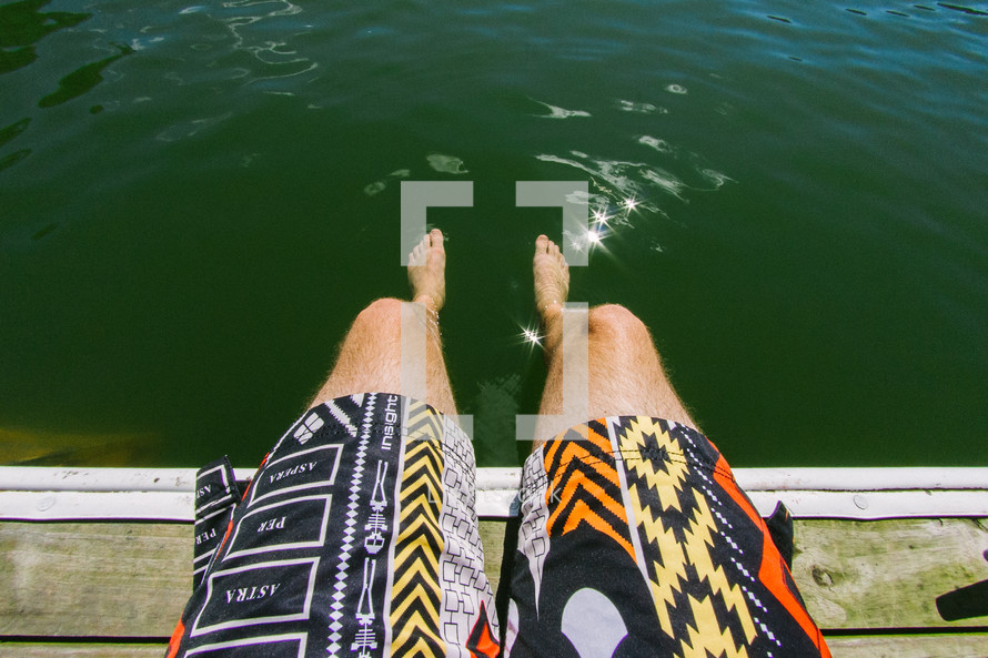 feet in the water hanging over a dock 