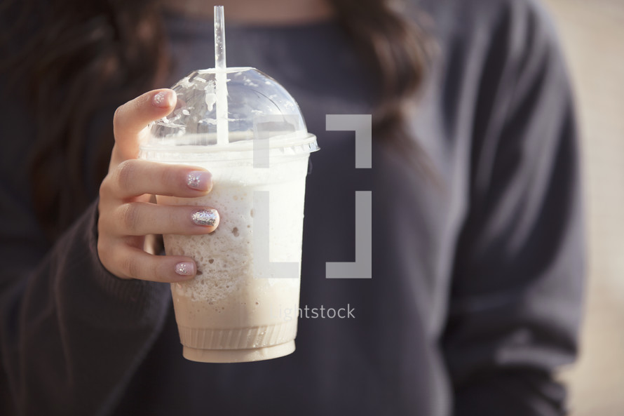 Hand holding a frozen latte.