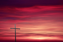 cross against a pink sky at sunset 