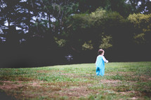 toddler girl walking in grass 