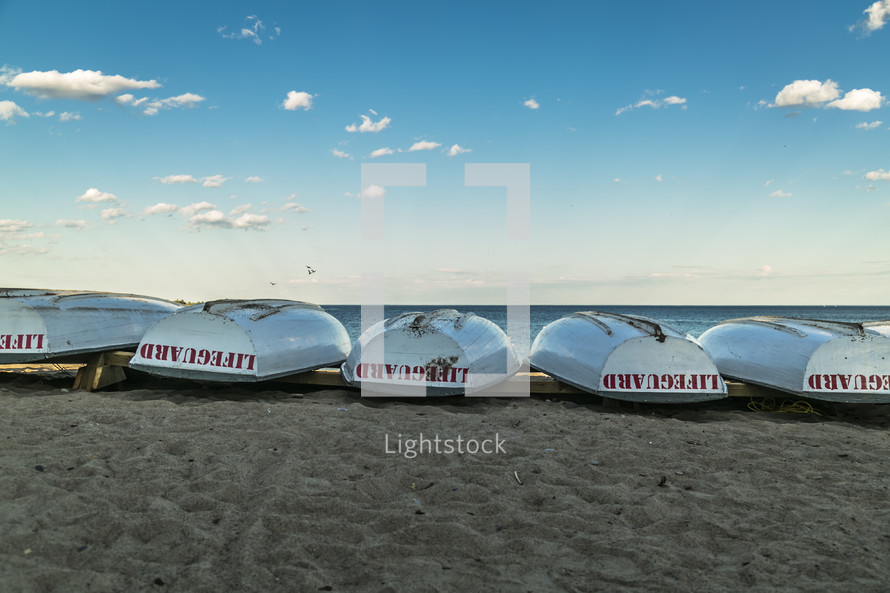 overturned lifeguard boats on a shore 