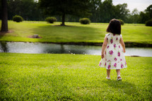 toddler girl in a sundress standing in grass 