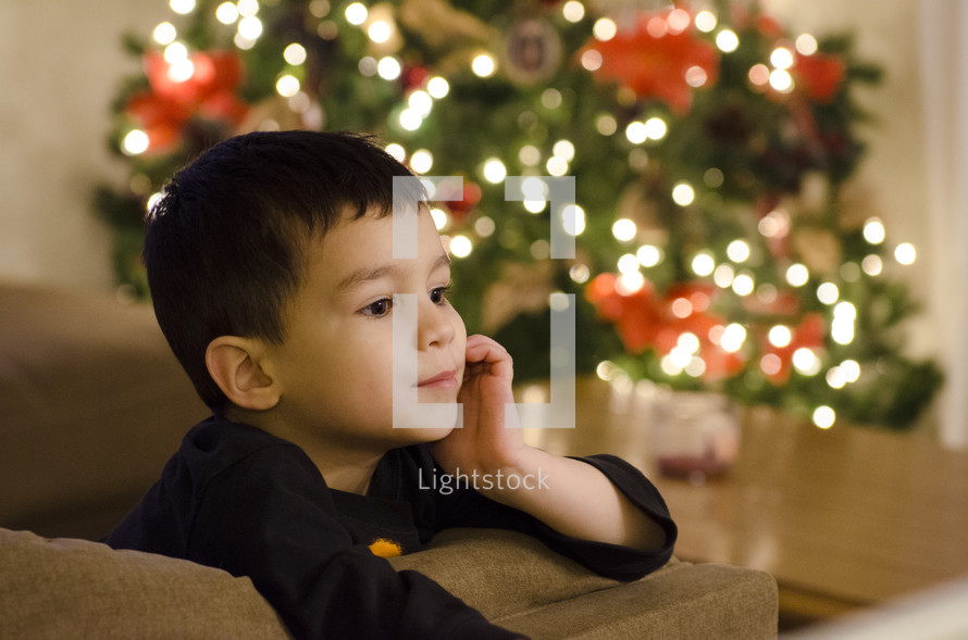 child near a Christmas tree 