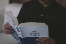 a boy reading a Bible 