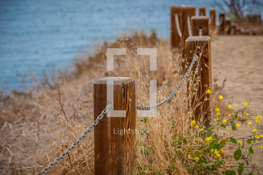 chains on posts forming a fence along a shore 