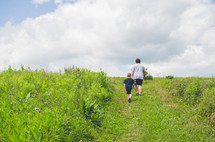 father and son walking through a field 