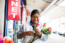 a woman holding and selling roses 