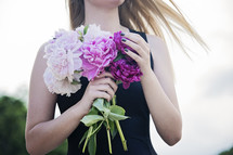 torso of a young woman holding flowers