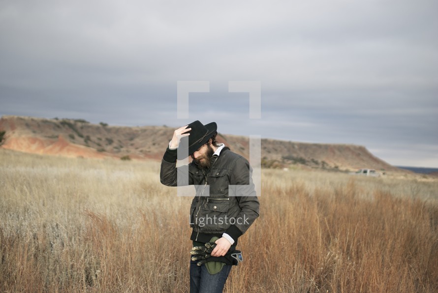 man with a black hat in a field 