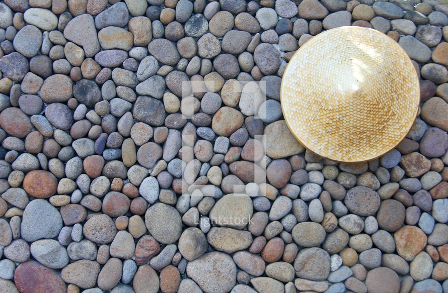 straw hat on stones 