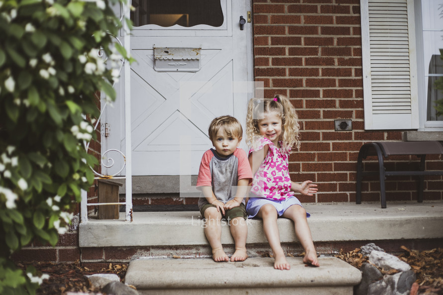 kids sitting on steps on a front porch 