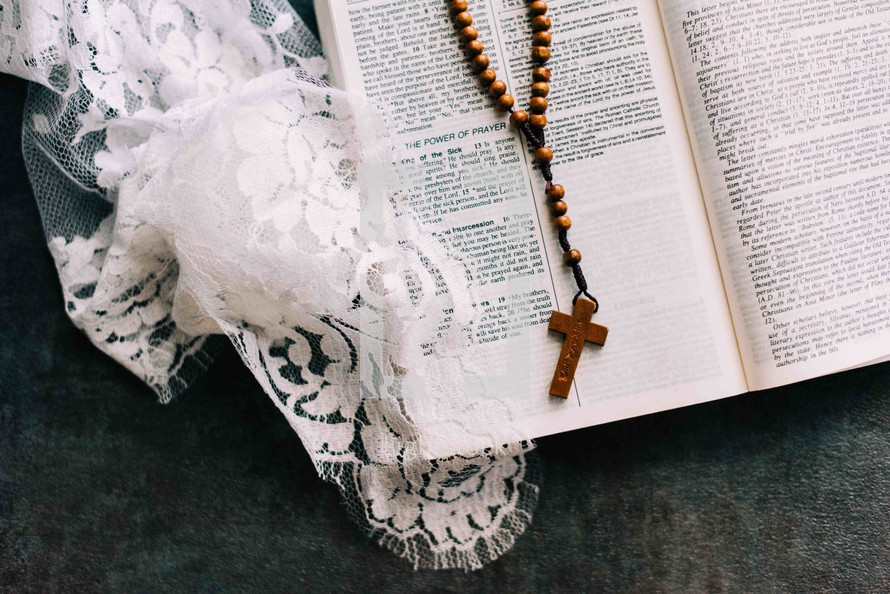 wooden rosary beads on a Bible 