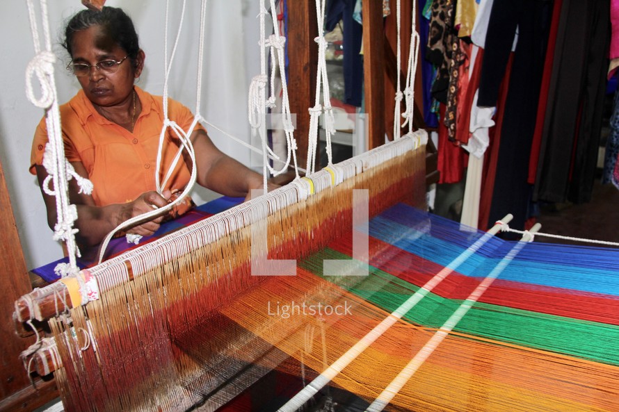a woman weaving on a loom 