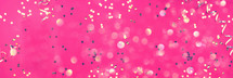 New year, Christmas background. Golden shiny glitter, sparkles, light bokeh on pink background. Banner with copy space. Festive backdrop for greeting card