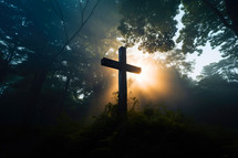 Cross in the forest at sunrise with rays of light coming through the trees