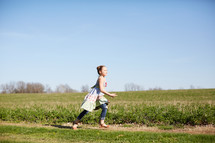 a girl running in a field of grass