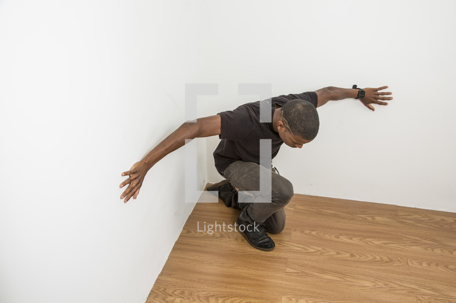 man pushing against a wall 