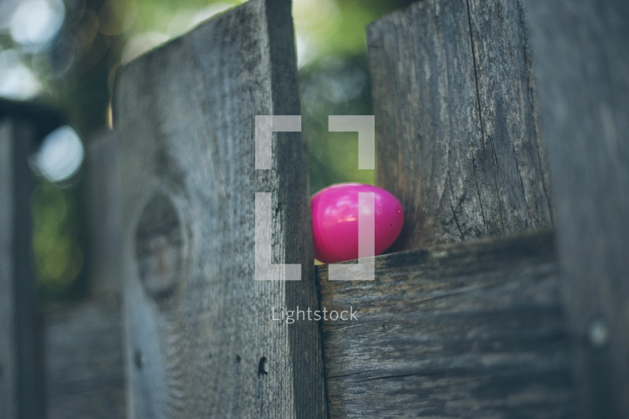Easter egg on a  wooden fence.
