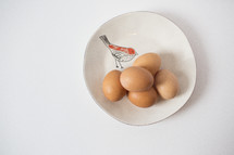 bird on a plate and eggs 