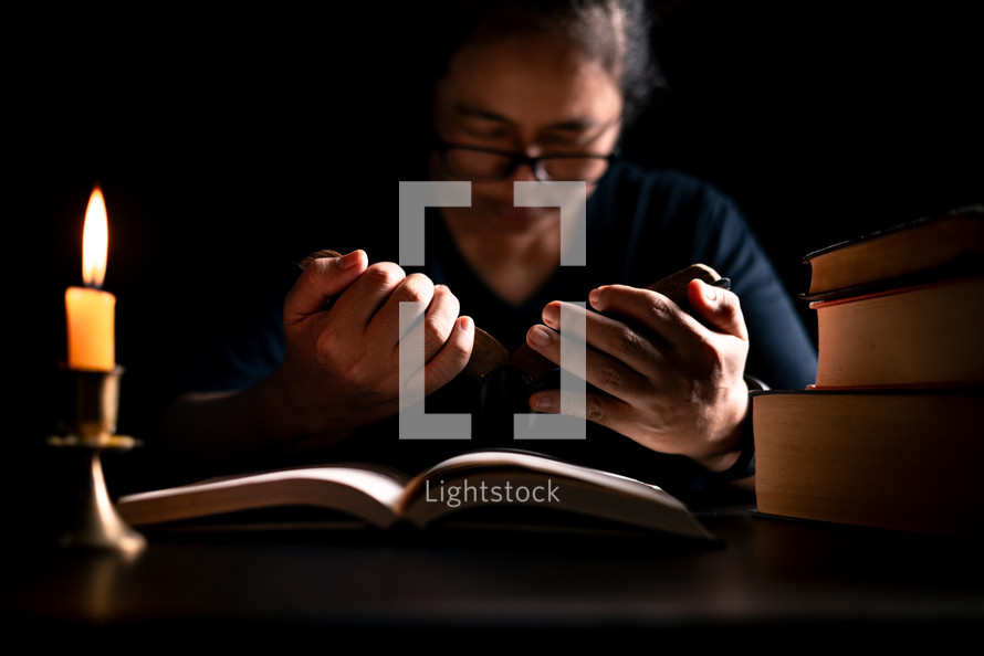 Bible and candlelight with studying woman