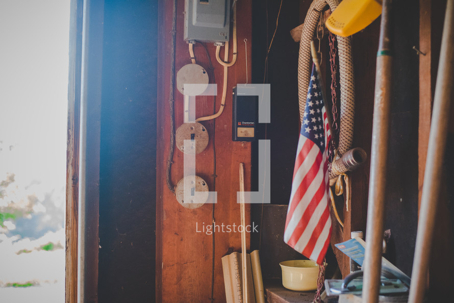 hose and American flag hanging in a barn 